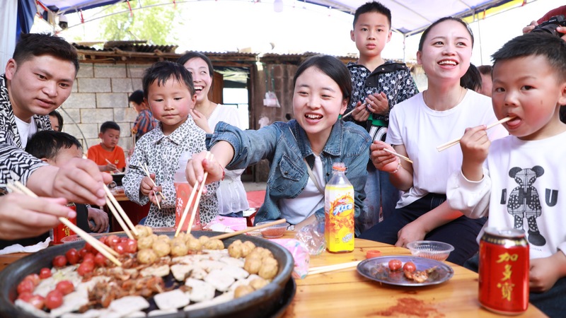 4月17日，游客在贵州省大方县石桅村农家乐享受美食。周训贵摄