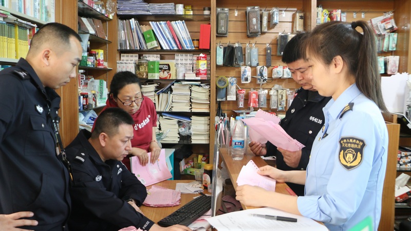 执法人员仔细核对进销货台账  谭忠娅  摄.JPG