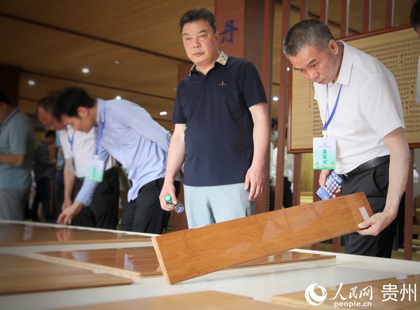 参会宾客考察当地企业生产的竹地板。人民网 龙章榆摄