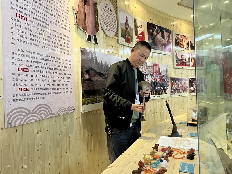 桐梓县文化馆非遗办公室负责人曾学林整理非遗展品。彭光杰摄