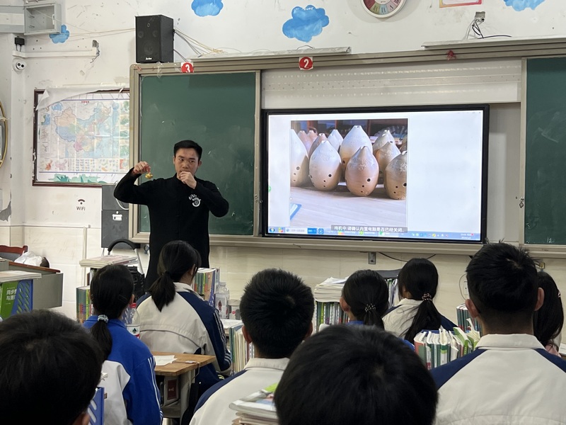 桐梓泥哨第四代传承人姚德波在蟠龙高中给学生讲解桐梓泥哨，手把手教学生制作泥哨。彭光杰摄