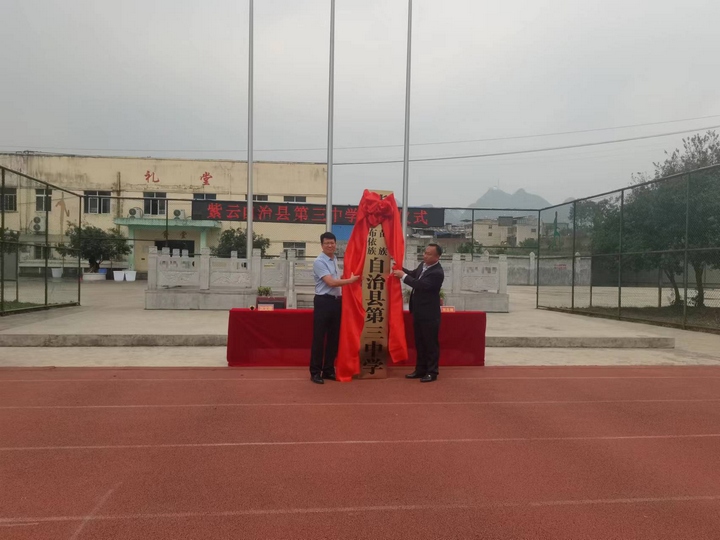 紫云县委教育工委专职副书记、县教育和科技局党组书记、局长周文科（左）为紫云三中揭牌。