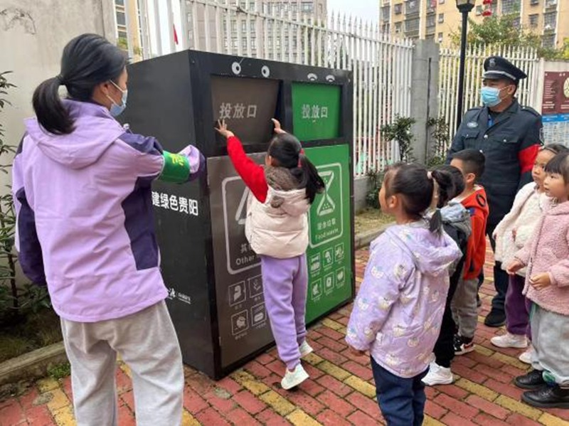 图片(3)教师正在指导学生投放垃圾