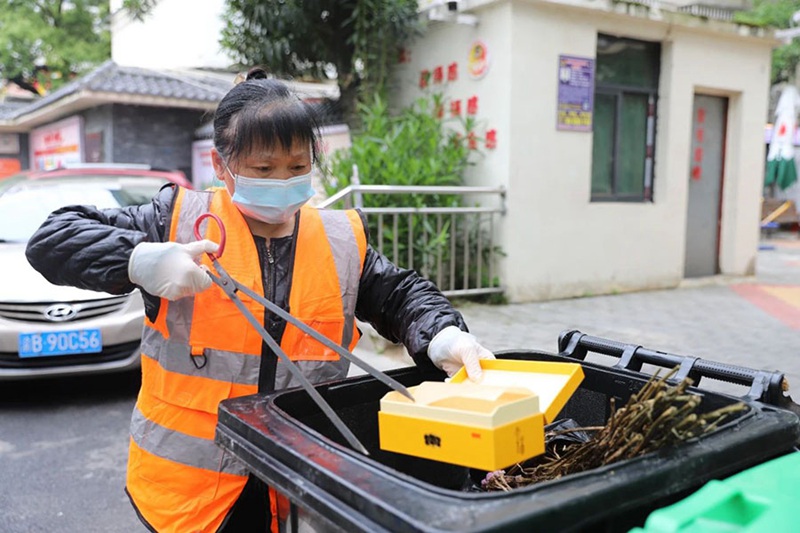环卫工人吴运坤正在对垃圾进行二次分类。张钰佳摄