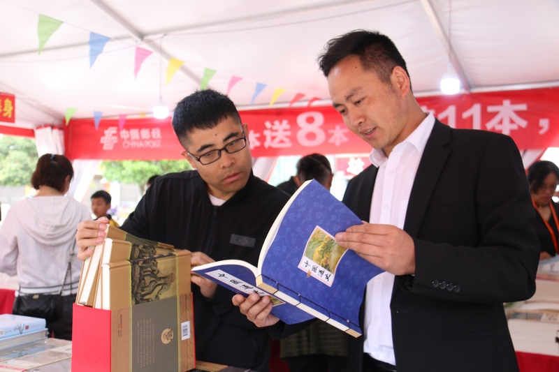 5月6日，两名干部在贵州省大方县2023年全民阅读活动现场翻阅国学书籍。肖炜烨 摄.JPG