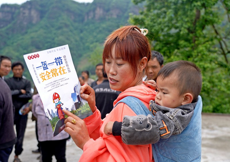 2023年5月9日，貴州省納雍縣水東鎮簸落村，家長在給小朋友講解交通安全知識。（楊英 攝）