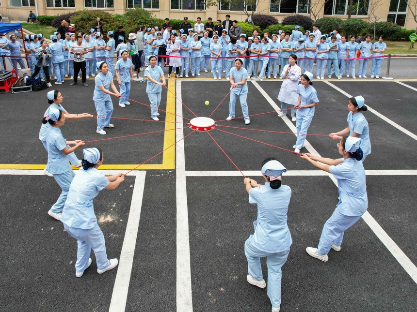 2023年5月11日，贵州省黔南布依族苗族自治州罗甸县中医院的医护人员在进行“同心鼓”趣味活动。