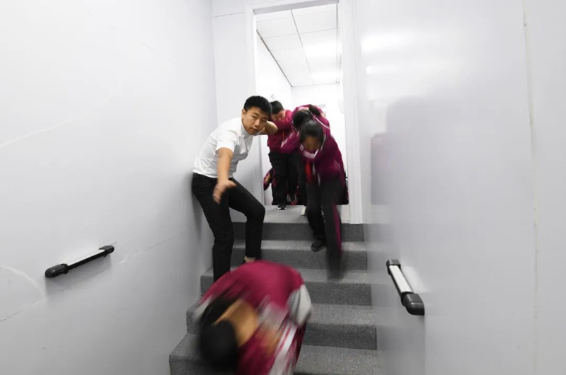 在南明区花果园第三小学消防体验馆，同学们正在老师的引导下进行火灾应急逃生演练。