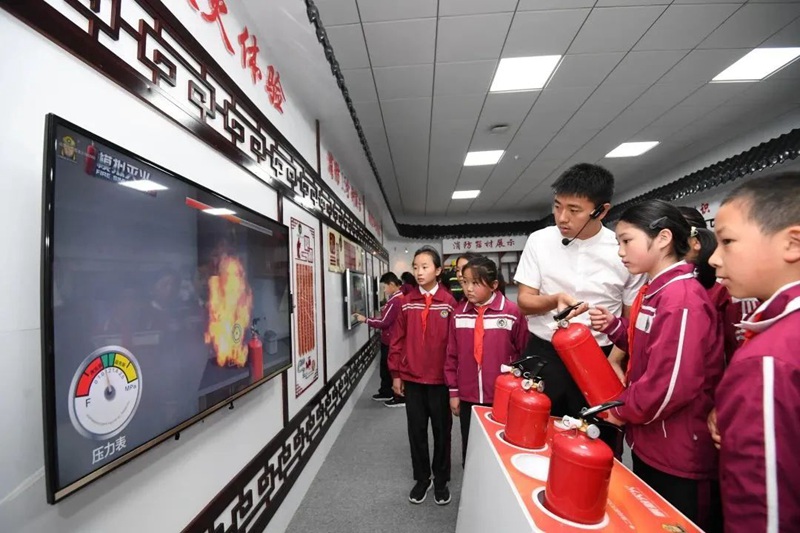 在南明区花果园第三小学消防体验馆，学生们正在老师的指导下进行消防灭火体验。