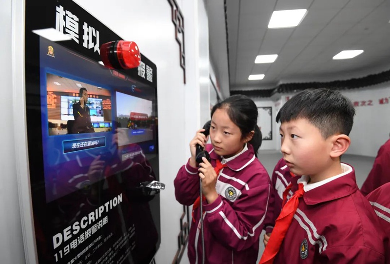 在南明区花果园第三小学消防体验馆,一名小学生正在体验拨打消防报警电话。