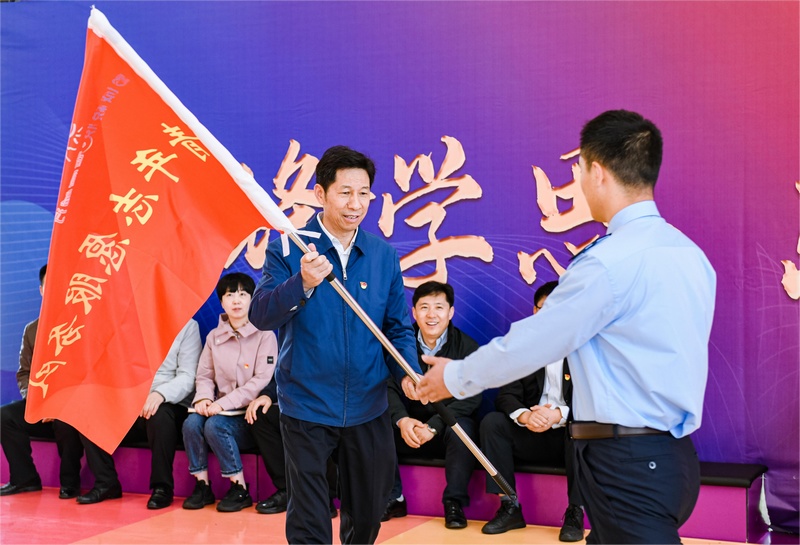 国家税务总局主题教育第二巡回指导组组长秦守成为贵州省税务局机关青年志愿服务队授旗。罗浩摄
