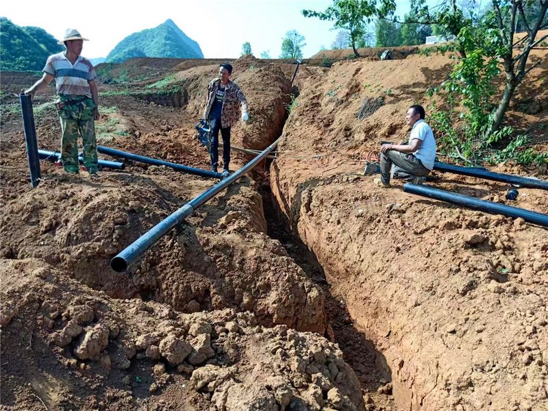 村民正在铺设引水管道。