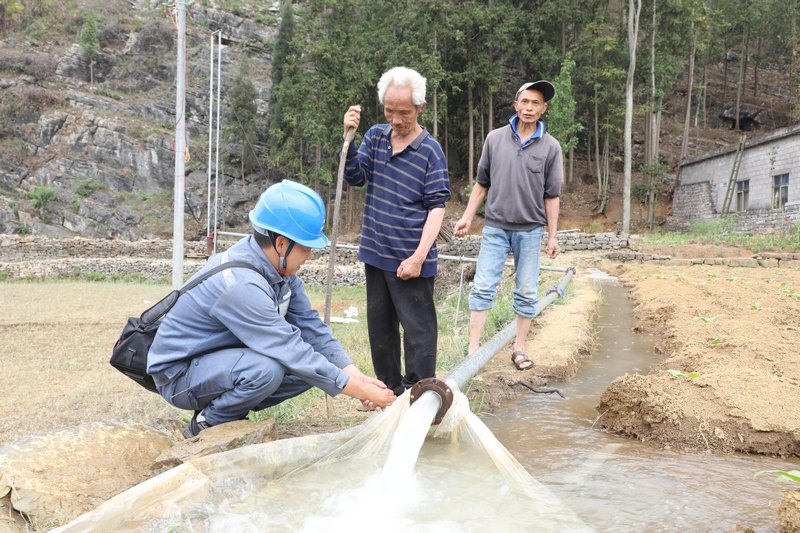 南方電網興仁供電局配網工作人員與村民了解抽水管道動能情況.JPG