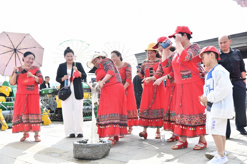5月28日，在贵州省毕节市百里杜鹃管理区黄泥乡朝门村拍摄的游客正在体验打糍粑。