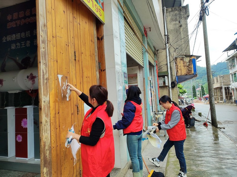 紙房鄉巾幗志願者清理街道廣告。