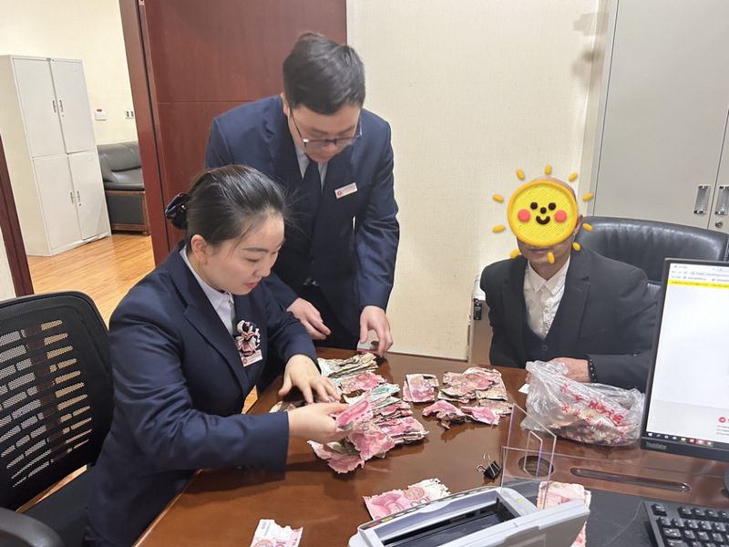 銀行工作人員為客戶清理殘幣。