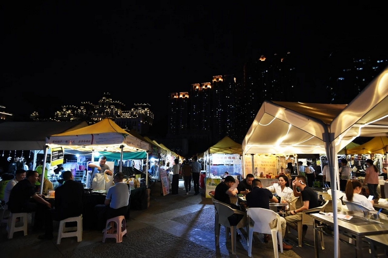 市民游客在南明区花果园湿地公园海豚广场上的“小花”直播路演场品味美食。