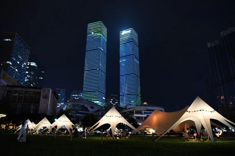 市民游客在南明区花果园湿地公园海豚广场上的“野地部落”露营地休闲消费。