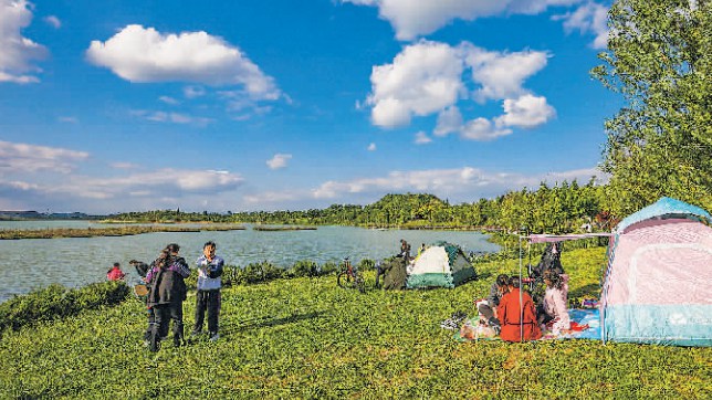 市民在貴安新區月亮湖公園草坪上休閑娛樂。 貴陽日報融媒體記者 石照昌 攝