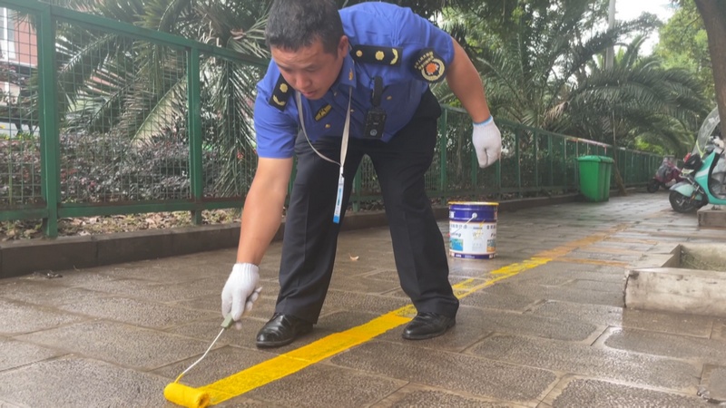 安顺经开区城管划线整治马路摊点，摊贩不再“打游击”。程倩摄