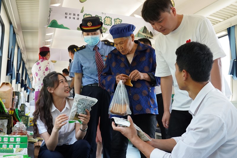 4、端午假期，旅客在5630次“小慢车”上集市车厢里选购农产品。.JPG