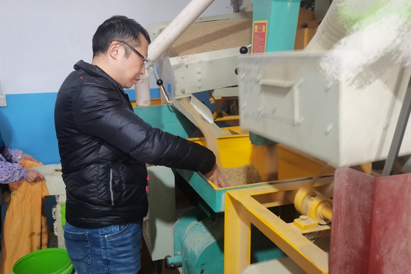 4 赵晓林在查看大米加工设备工作情况。(受访者供图)