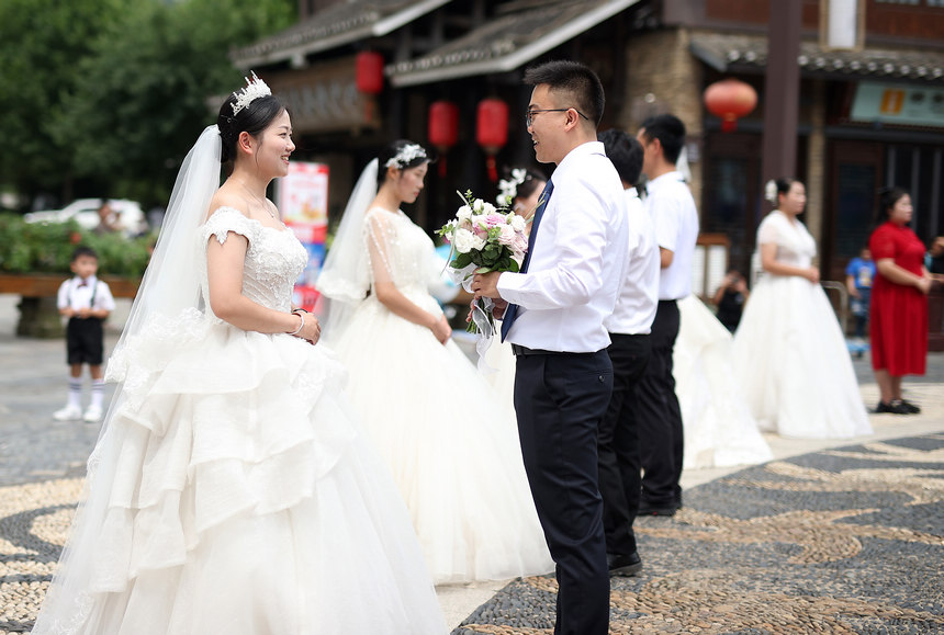 集體婚禮上，新郎給新娘獻花。 