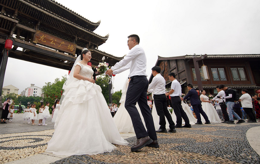 集體婚禮上，新郎給新娘獻花。 