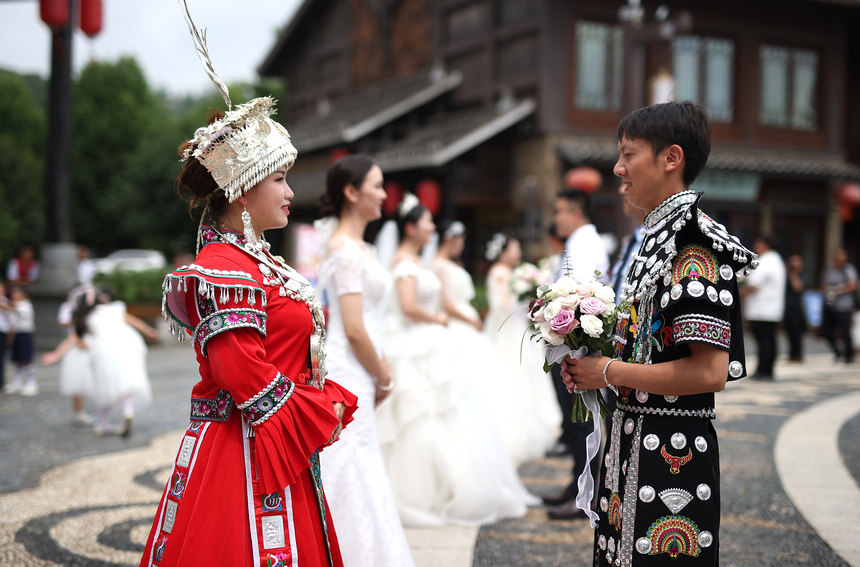 集體婚禮上，新郎給新娘獻花。 