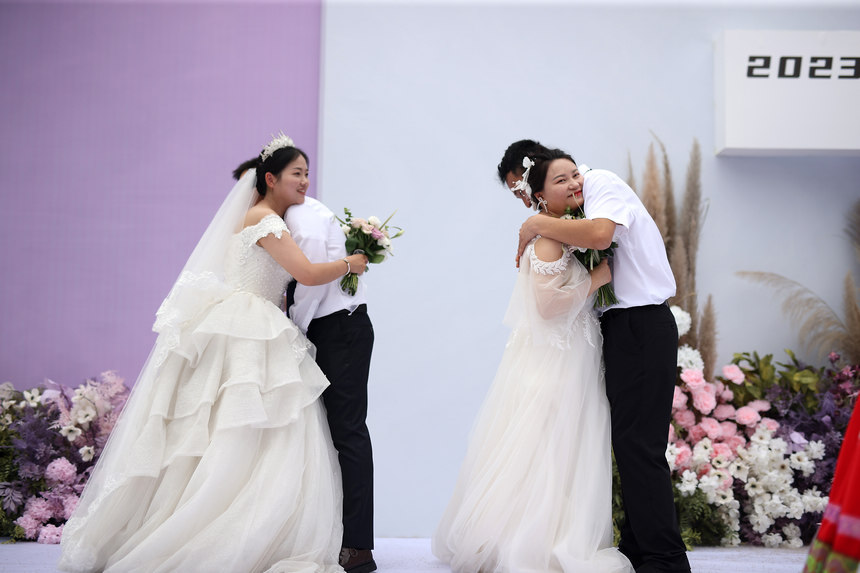 新郎、新娘在集體婚禮儀式上相擁。