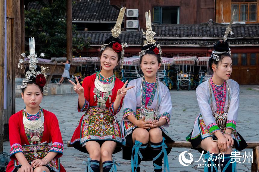 侗族姑娘坐在广场上合影。人民网 阳茜摄
