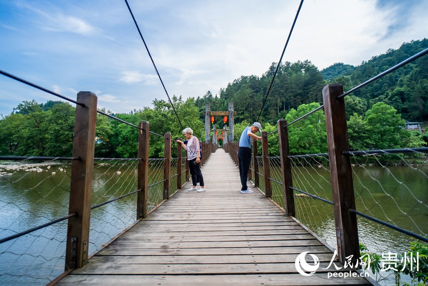游客站在吊桥上看风景。人民网记者 涂敏摄