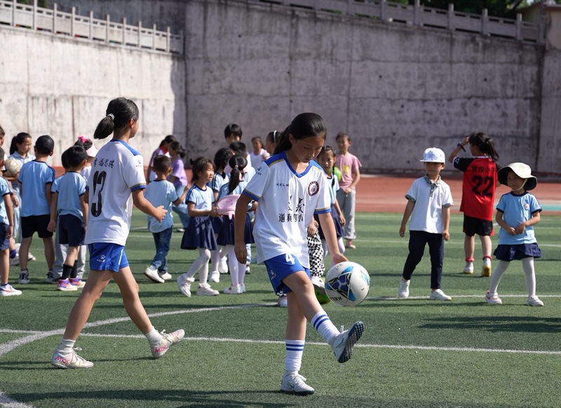 道真自治縣第四小學學生在練習踢足球。