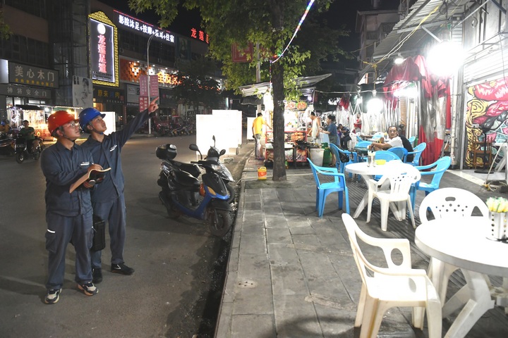 南方电网工作人员检查夜市小商户线路。