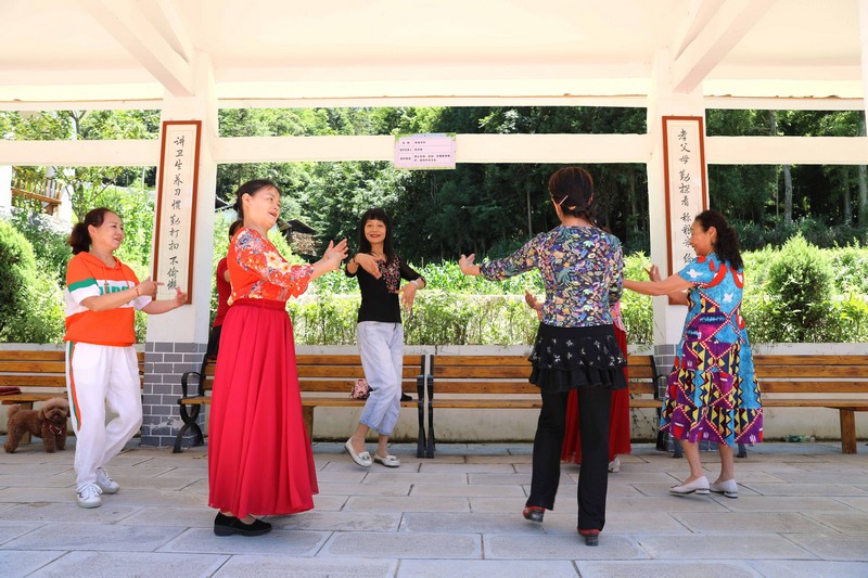 7月5日，游客在寬闊鎮紅河村長廊內跳舞。