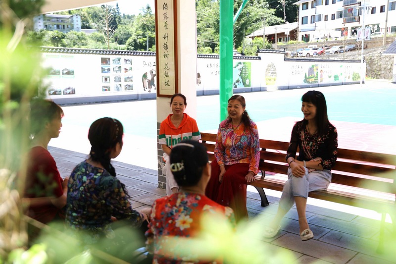 7月5日，游客在寬闊鎮紅河村長廊聊天。