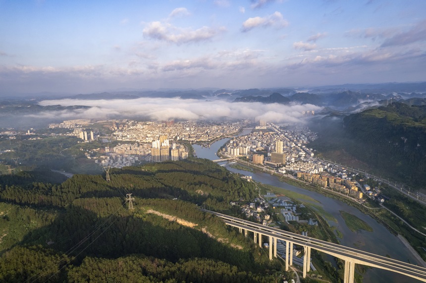 2023年7月10日，雨后的贵州省黔东南州施秉县城，远处的云雾与绿水青山、错落有致的建筑相映成景，构成了一幅秀美迷人的生态画卷。