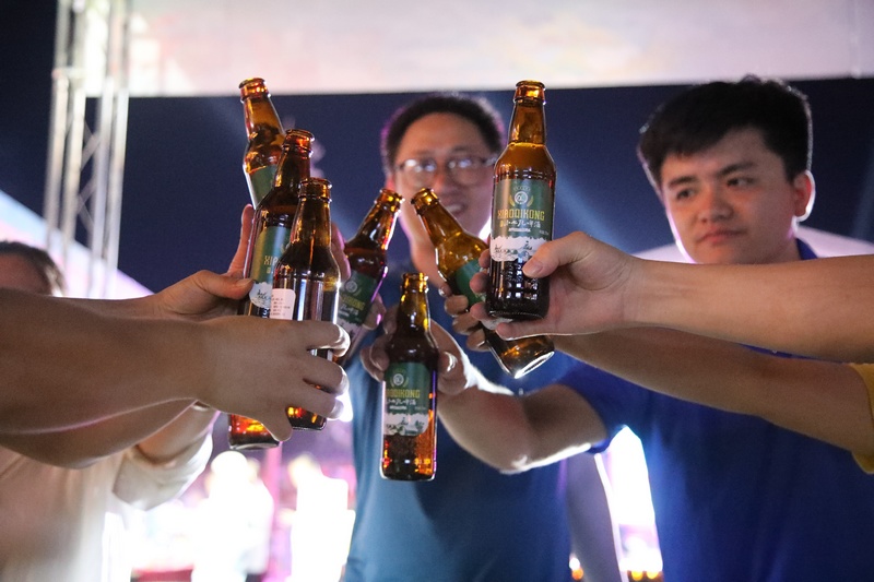 游客們舉杯打卡荔波首款”小七孔啤酒“，眾人開懷暢飲。