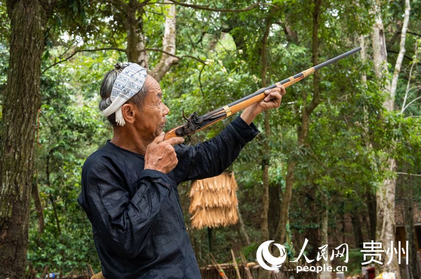 岜沙苗寨的村民為游客展示火槍。人民網 陽茜攝
