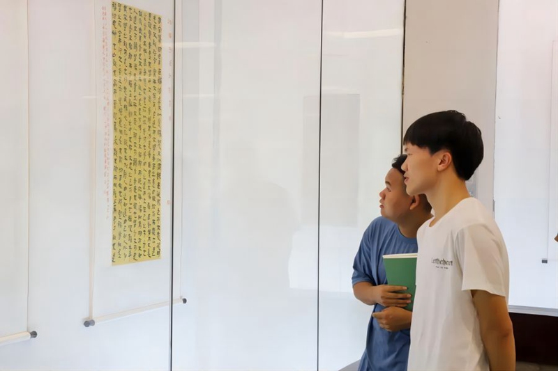 书法爱好者们认真欣赏作品。