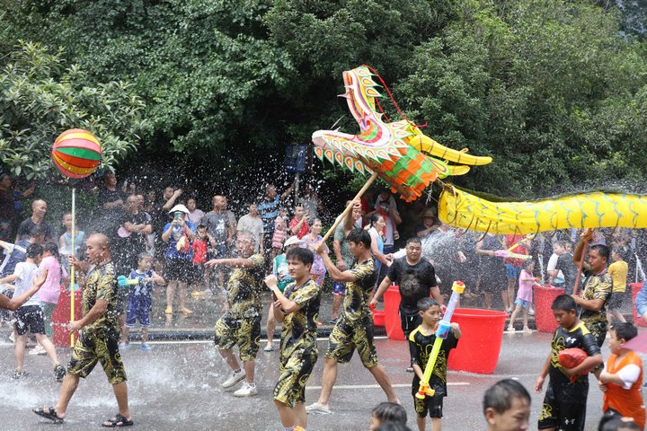 当地群众和游客在黔东南州施秉县玩水龙。