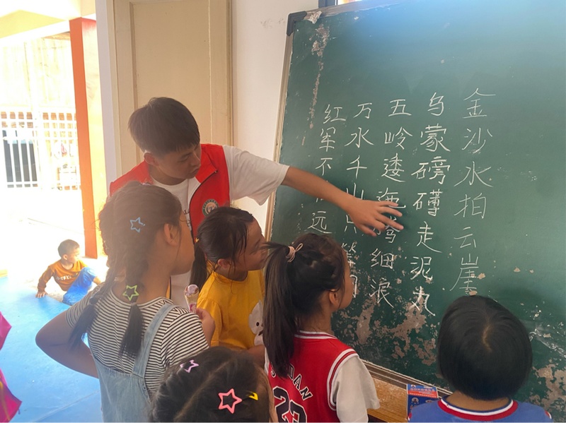 志願者教小朋友《七律·長征》古詩。