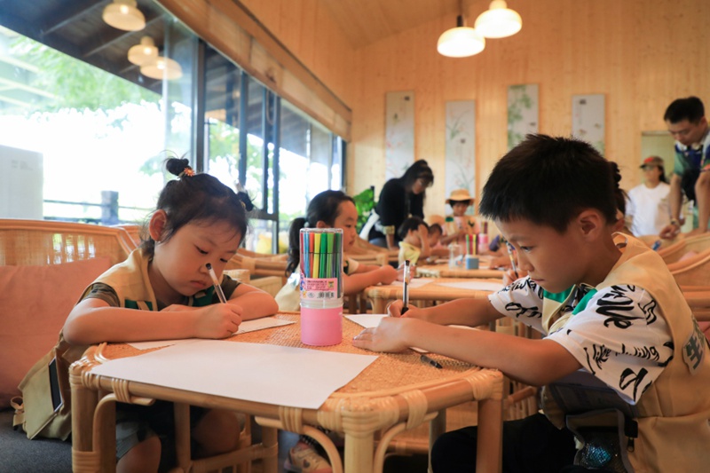 4学生们拿起画笔在扇子上绘制图案