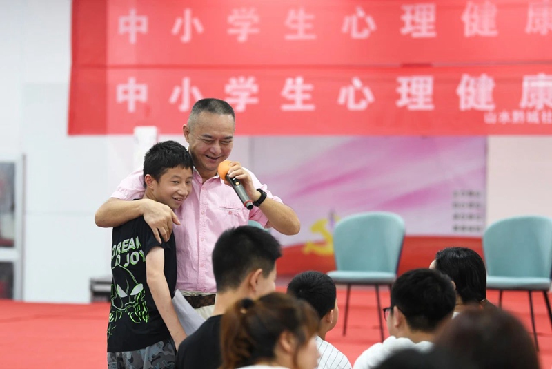 图片（4）南明区西湖社区卫生服务中心的专家与孩子进行互动。