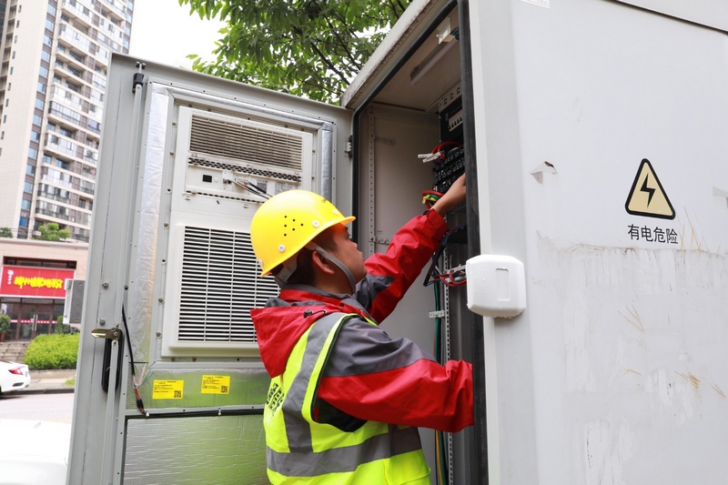 (2)2023年7月20日,維護人員檢查基站電箱設備。彭克貴攝