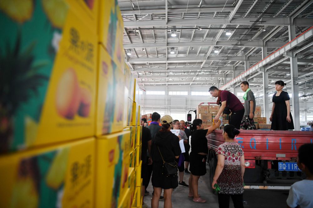 工作人員和志願者在河北省涿州市鋼研物資儲備點內將捐贈物資裝車外運（8月5日攝）。新華社記者 牟宇 攝