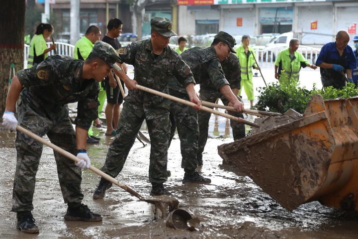 武警河北總隊保定支隊官兵在涿州市城西107國道沿線清理淤泥（8月5日攝）。新華社發（王紅強 攝）