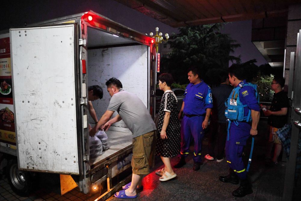 河北省涿州市職教中心安置點的工作人員在運送飯菜，准備發放給安置群眾（8月1日攝）。新華社記者 牟宇 攝