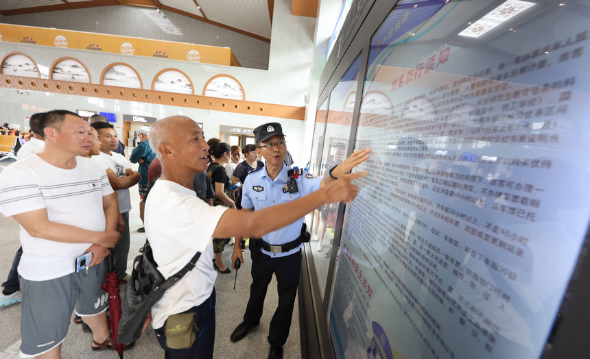 8月8日，铁路公安民警在贵南高铁荔波站向旅客宣传铁路安全知识。