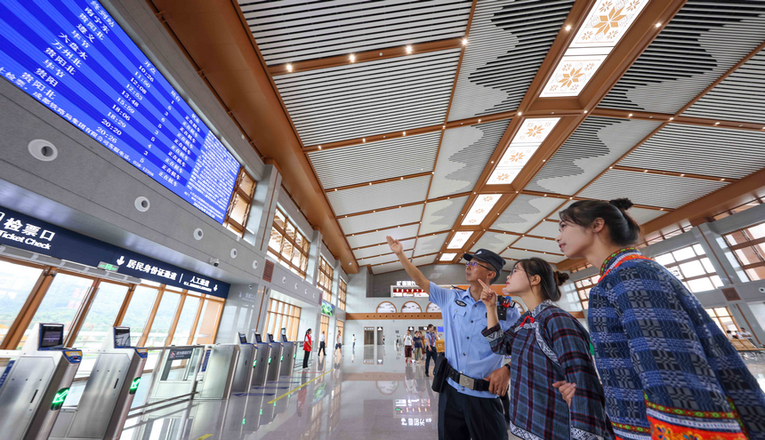 8月8日，铁路公安民警在贵南高铁荔波站候车室向旅客介绍列车运行时间信息。